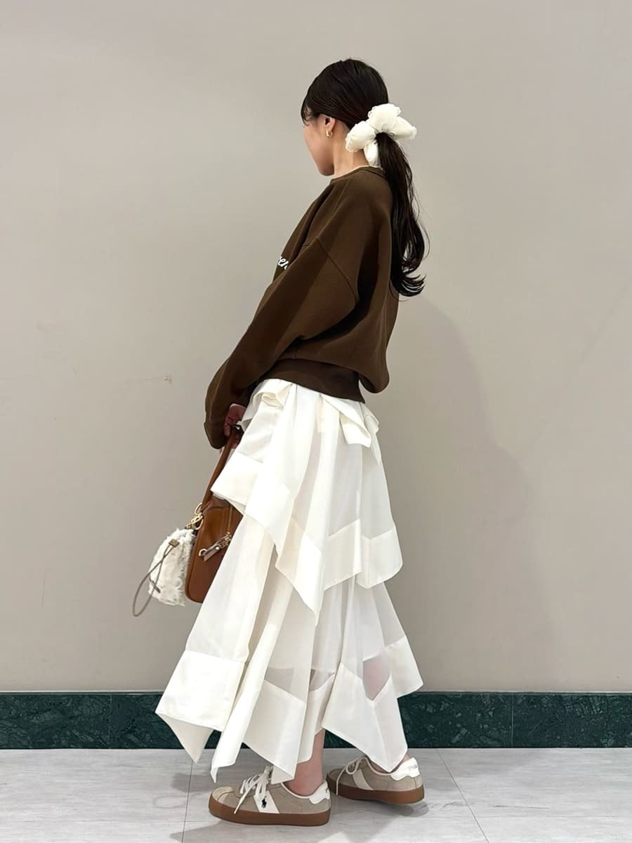 ホワイト系のスカート、ブラウン系のスウェット、イエロー系のボストンバッグを着用したレディースの春コーディネートの2枚目の写真