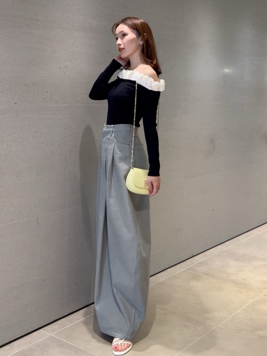 グレー系のデニムパンツ、ブラック系のニット/セーター、イエロー系のショルダーバッグを着用したレディースの冬コーディネートの5枚目の写真