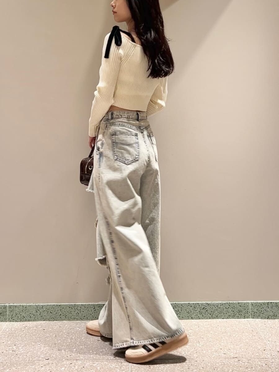 ホワイト系のニット/セーター、ブルー系のデニムパンツ、ブラウン系のボストンバッグを着用したレディースの秋コーディネートの3枚目の写真