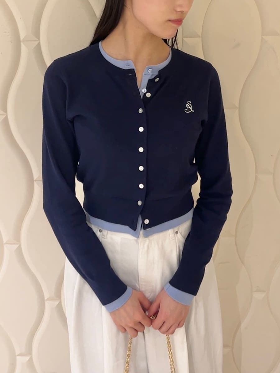 ブルー系のカーディガン/ボレロ、ブラック系のパンプス、ブラック系のショルダーバッグを着用したレディースの冬コーディネートの5枚目の写真