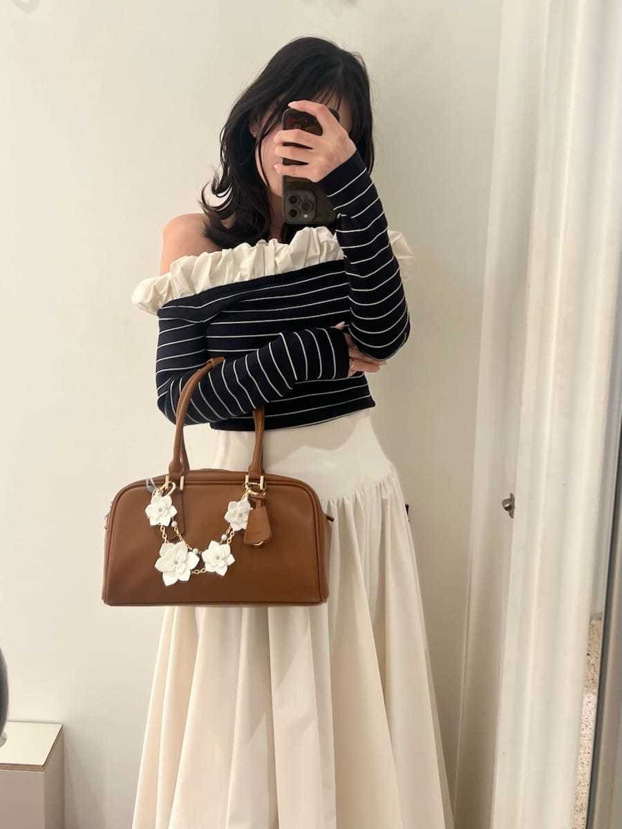 ブラウン系のブーツ、ホワイト系のスカート、その他のニット/セーターを着用したレディースの冬コーディネートの4枚目の写真