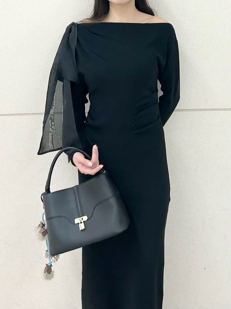 ベージュ系のブーツ、ブラック系のハンドバッグ、ブラック系のワンピースを着用したレディースの冬コーディネートの5枚目の写真