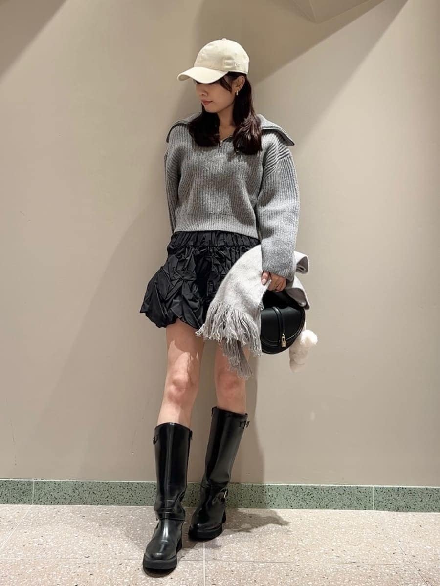 グレー系のニット/セーター、ブラック系のブーツ、ブラック系のハンドバッグを着用したレディースの冬コーディネートの4枚目の写真