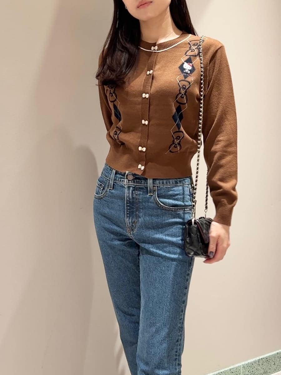 ブラウン系のカーディガン/ボレロ、ブルー系のデニムパンツ、ブラック系のショルダーバッグを着用したレディースの秋コーディネートの4枚目の写真