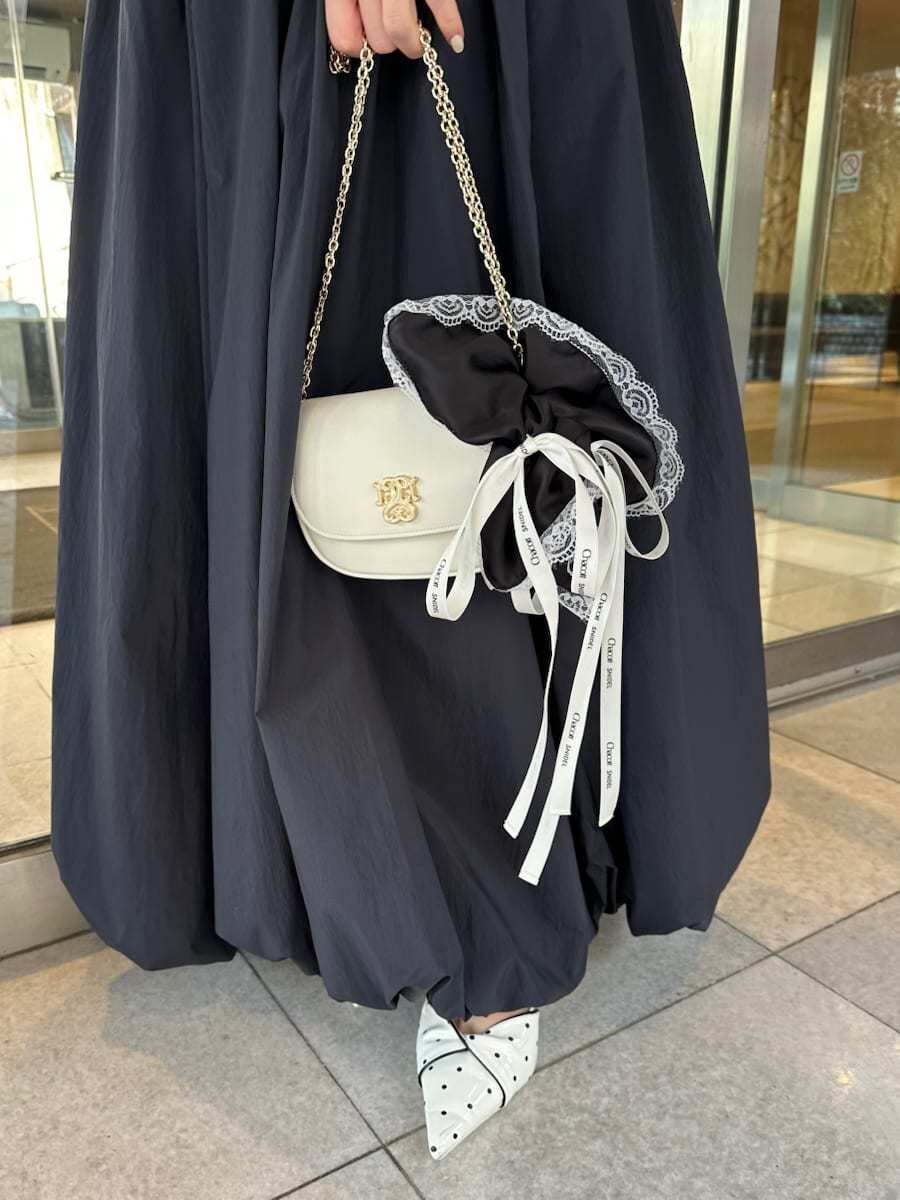 ホワイト系のショルダーバッグ、ブラック系のシュシュを着用したレディースの春コーディネートの7枚目の写真