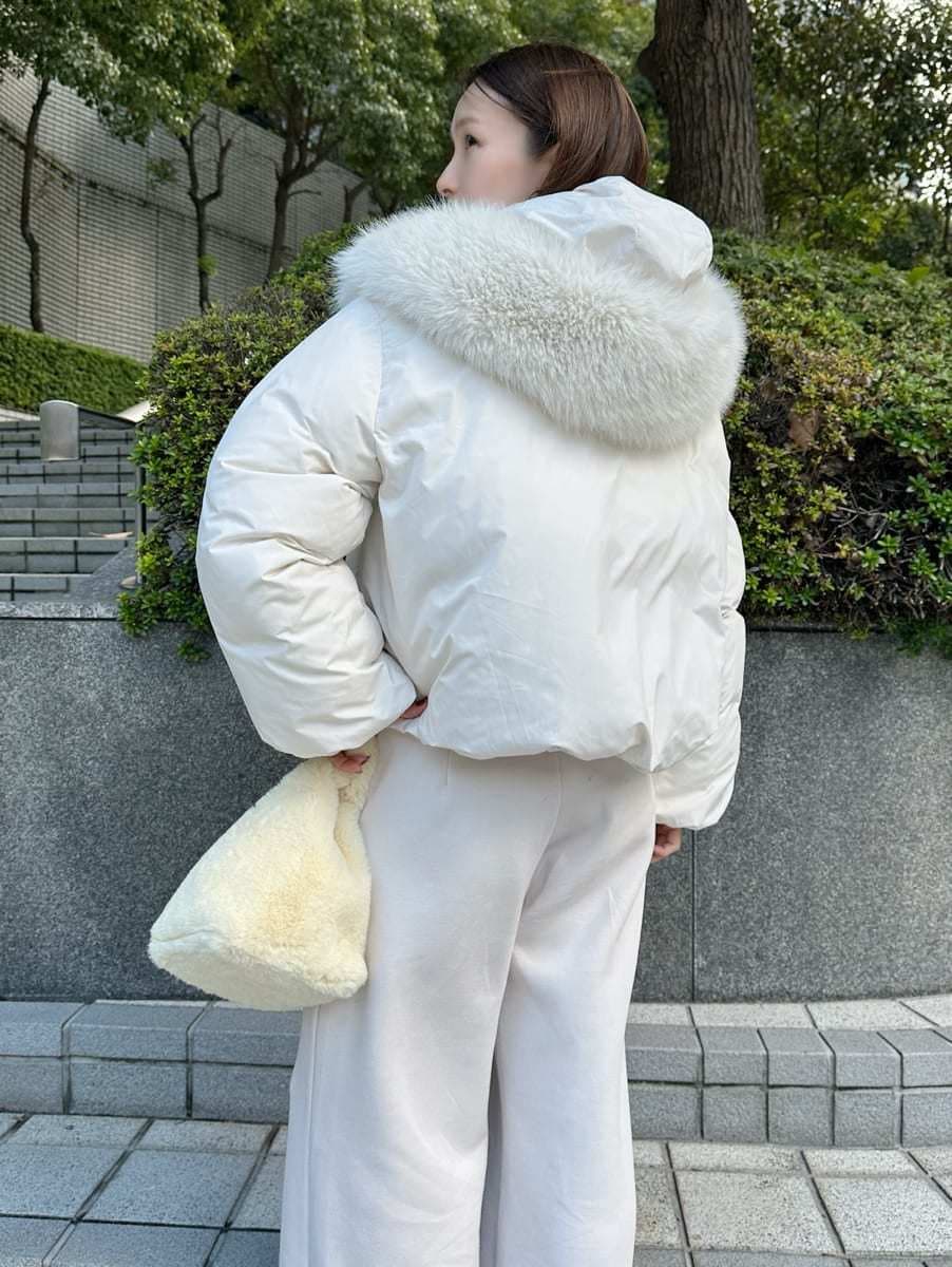 ホワイト系のダウンジャケット/コート、イエロー系のハンドバッグを着用したレディースの秋コーディネートの4枚目の写真