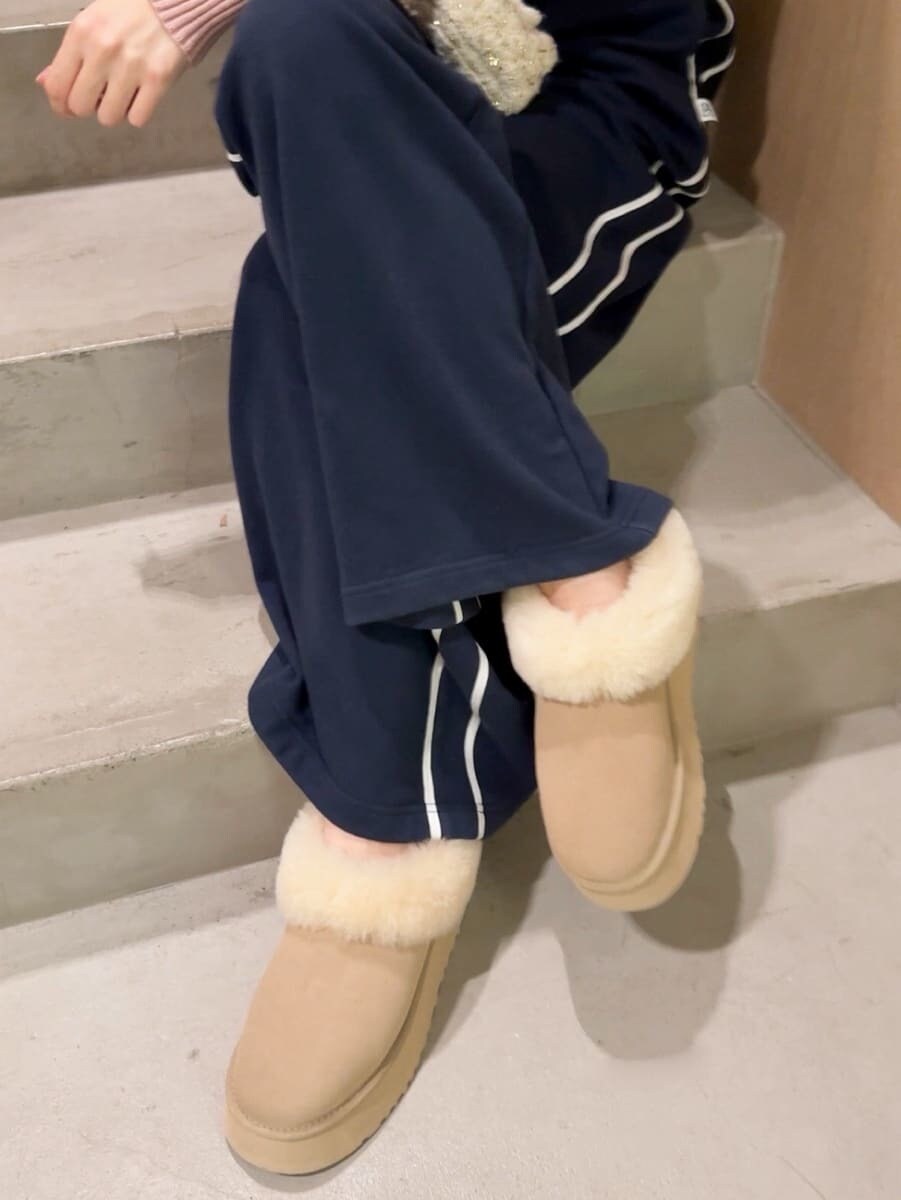 ピンク系のニット/セーター、ホワイト系のショルダーバッグ、レッド系のイヤリングを着用したレディースの夏コーディネートの6枚目の写真