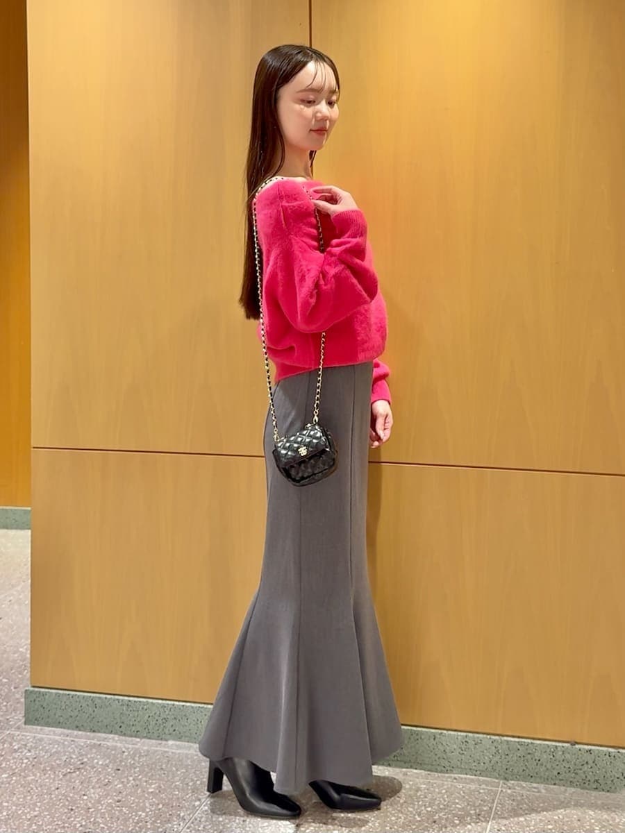 ブラック系のブーツ、ブラック系のショルダーバッグ、ピンク系のニット/セーターを着用したレディースの冬コーディネートの2枚目の写真