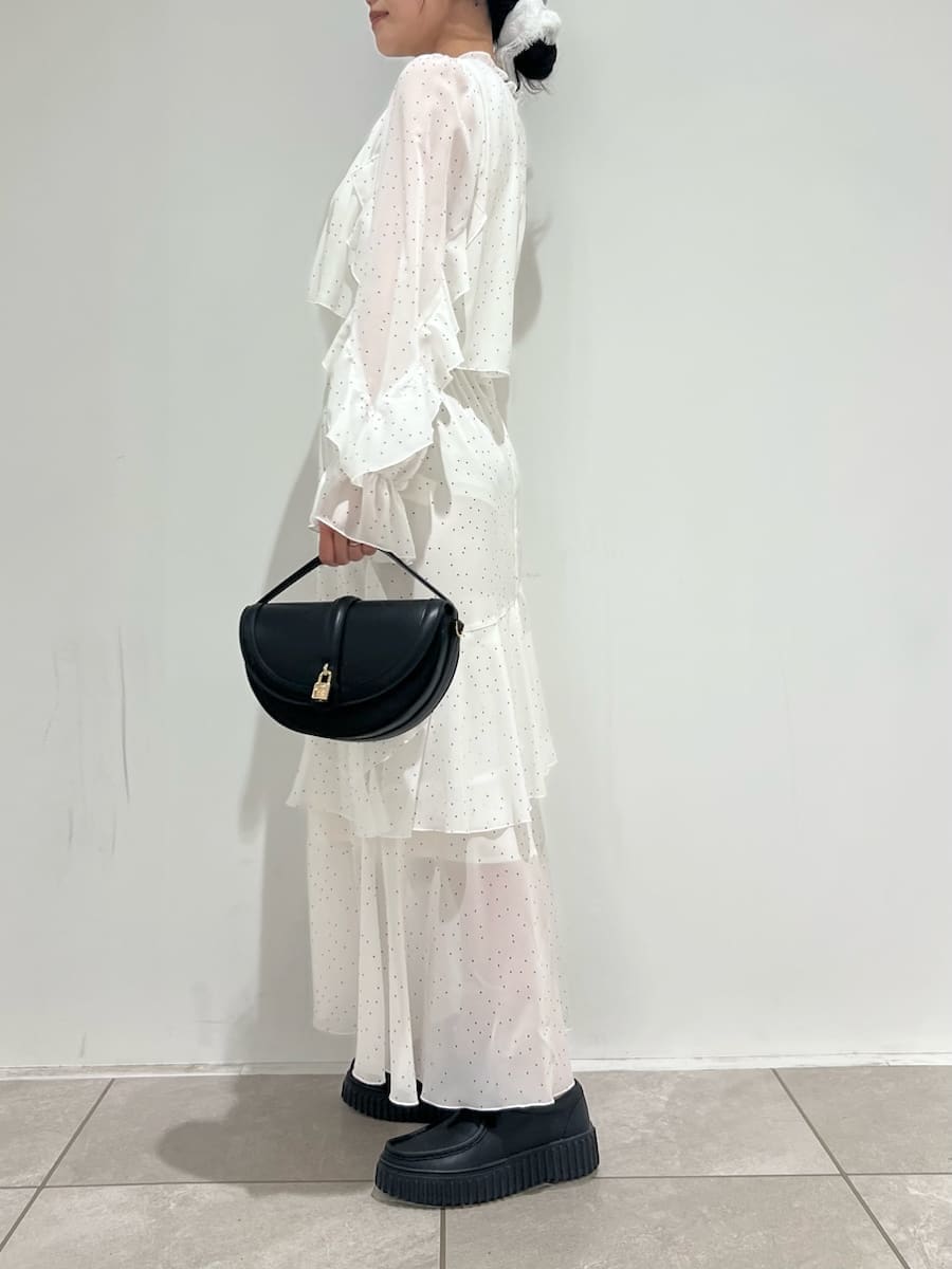 ブラック系のハンドバッグ、ブラック系のその他シューズ、その他のワンピースを着用したレディースの冬コーディネートの7枚目の写真