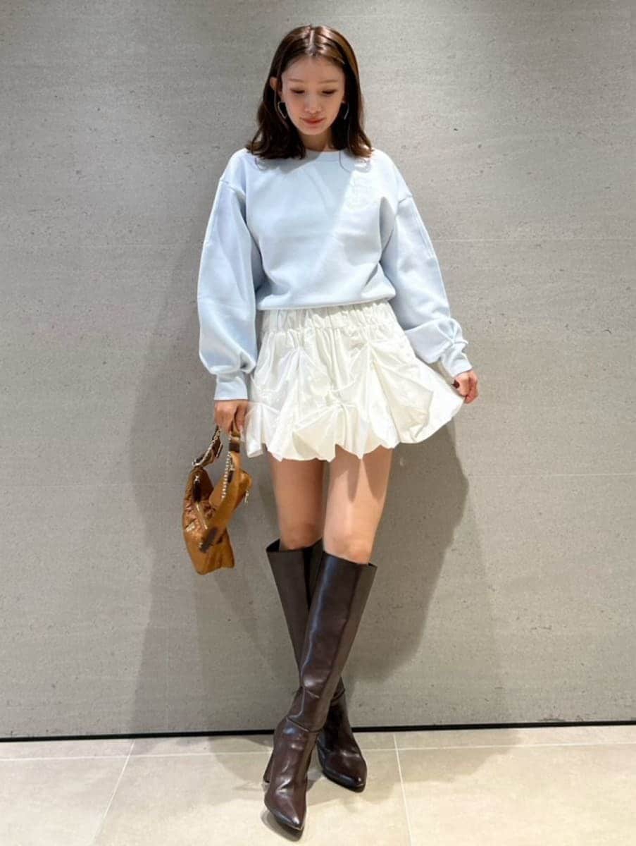 ブルー系のスウェット、イエロー系のショルダーバッグ、ホワイト系のその他パンツを着用したレディースの冬コーディネートの5枚目の写真