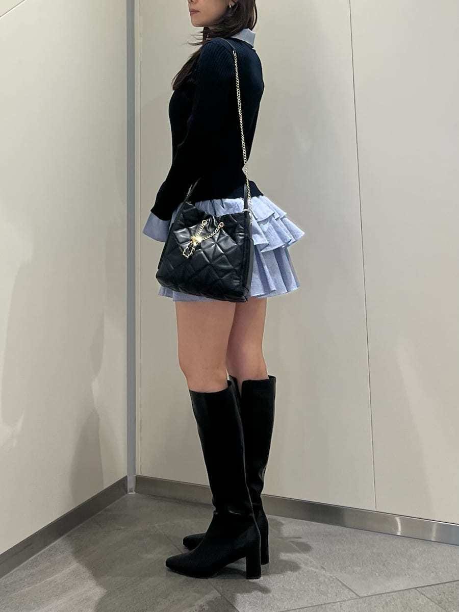 ブルー系のワンピース、ブラック系のブーツ、ブラック系のショルダーバッグを着用したレディースの秋コーディネートの2枚目の写真