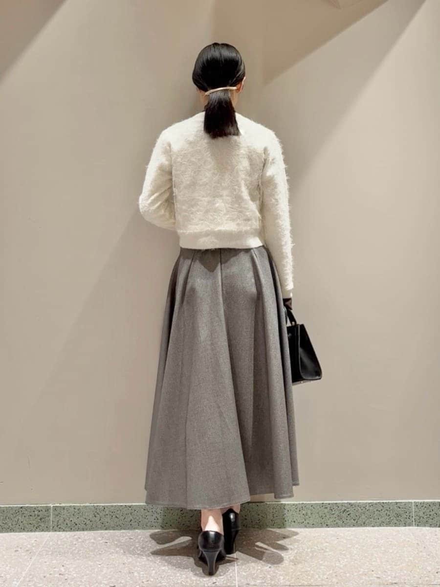 グレー系のスカート、ブラウン系のニット/セーター、ホワイト系のカーディガン/ボレロを着用したレディースの冬コーディネートの3枚目の写真