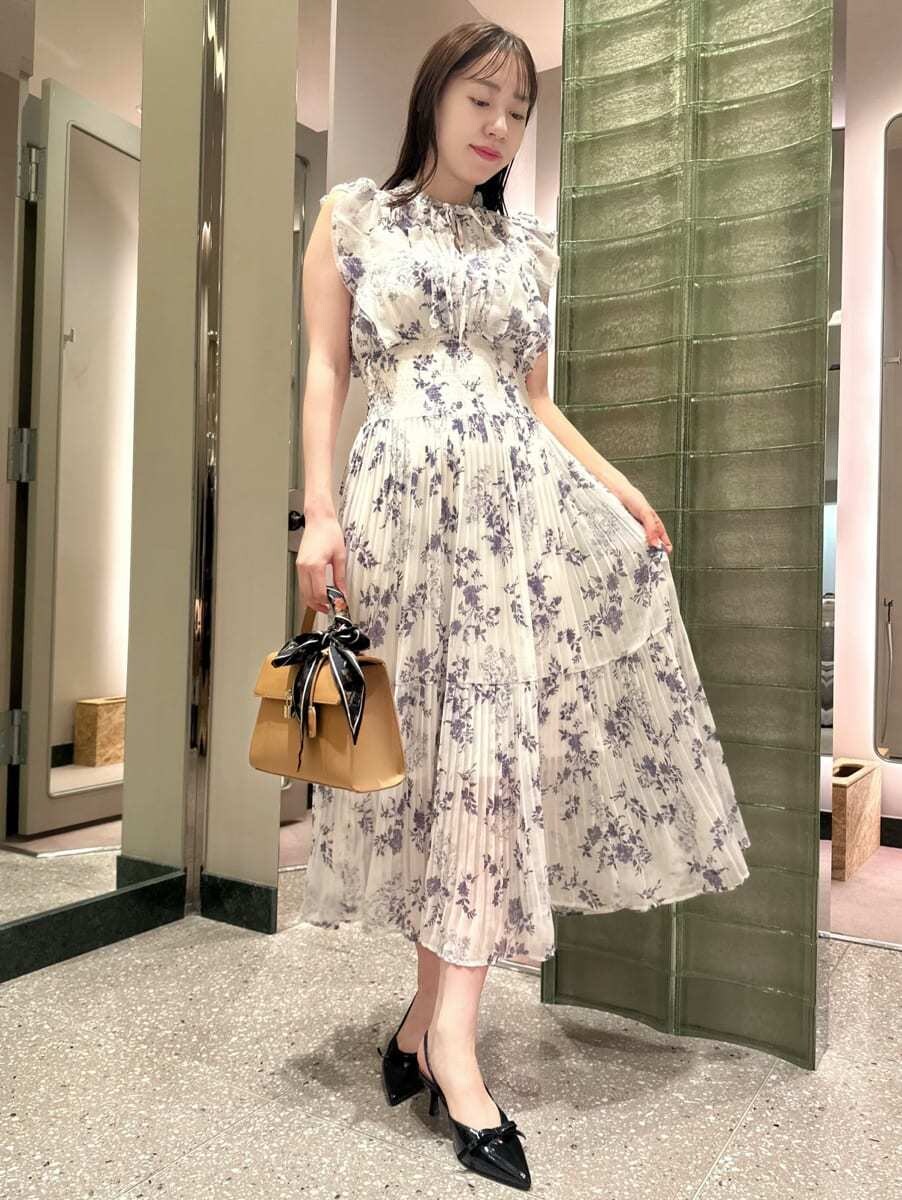 ブルー系のテーラードジャケット、ホワイト系のワンピース、イエロー系のハンドバッグを着用したレディースの秋コーディネートの2枚目の写真