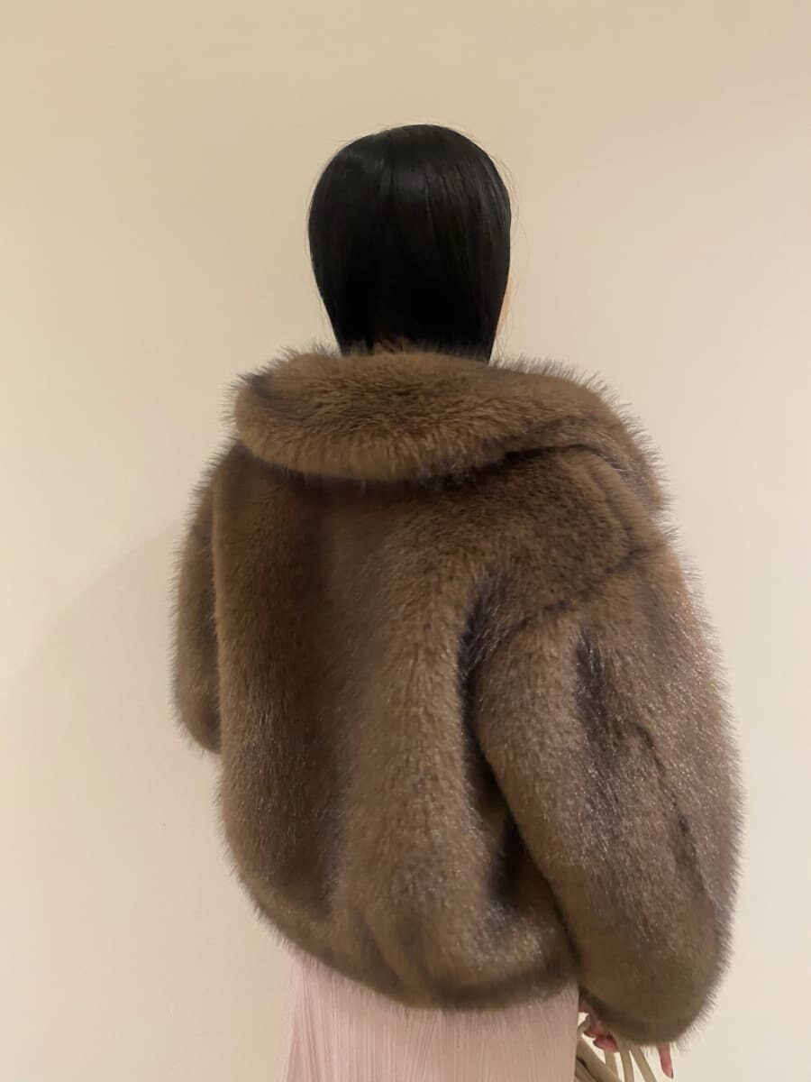 ブラウン系のチェスターコート、ピンク系のワンピース、ホワイト系のボストンバッグを着用したレディースの秋コーディネートの4枚目の写真