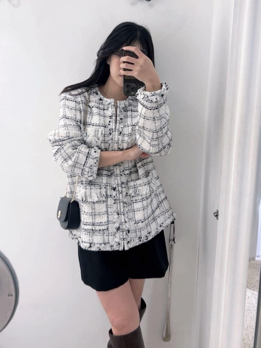 ブラウン系のブーツ、ホワイト系のノーカラージャケット、ブラック系のショルダーバッグを着用したレディースの冬コーディネートの5枚目の写真