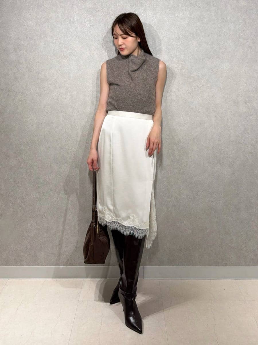 ベージュ系のトレンチコート、ホワイト系のスカート、ブラウン系のTシャツ/カットソーを着用したレディースの秋コーディネートの5枚目の写真
