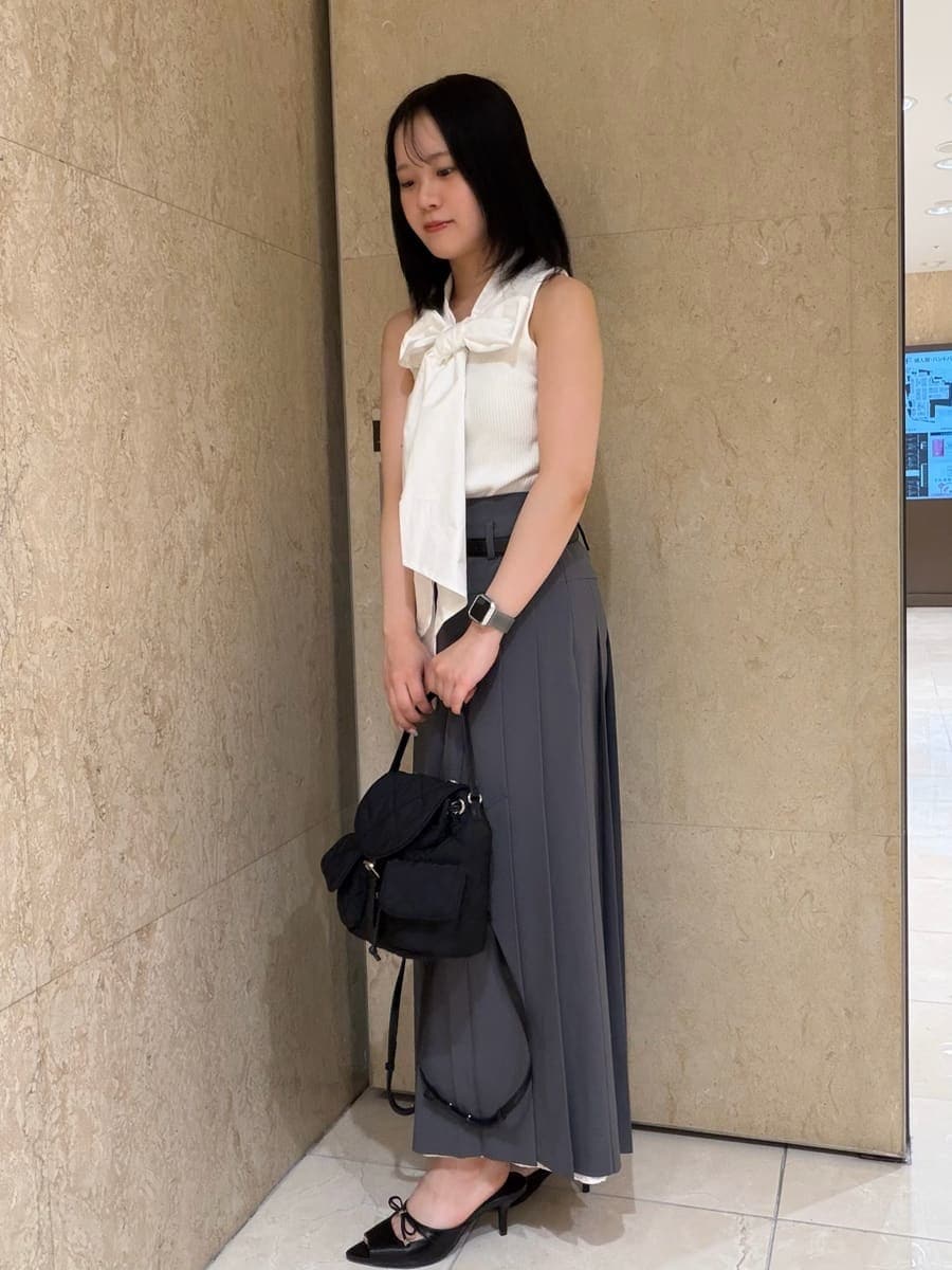 グレー系のスカート、ホワイト系のTシャツ/カットソー、ブラック系のサンダルを着用したレディースの夏コーディネートの3枚目の写真