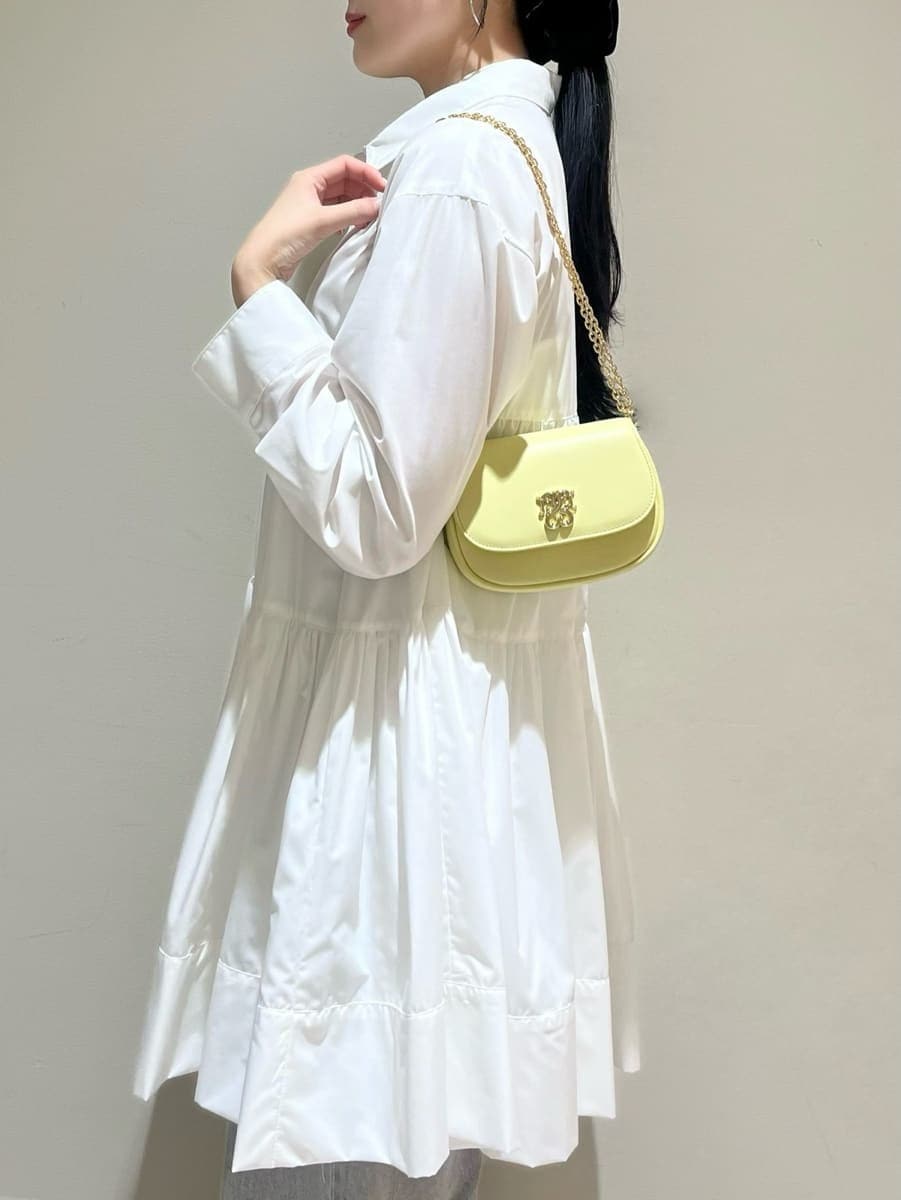 グレー系のデニムパンツ、ホワイト系のワンピース、イエロー系のパンプスを着用したレディースの春コーディネートの4枚目の写真