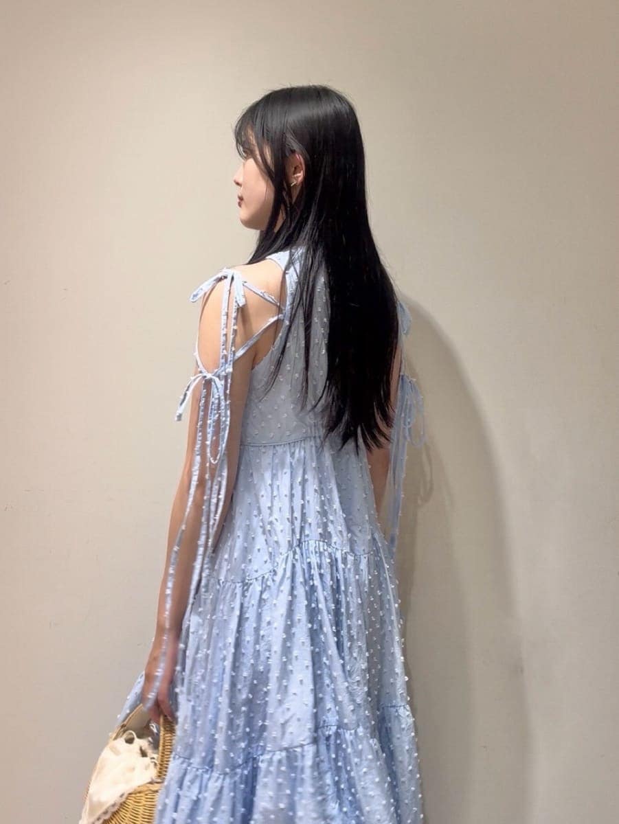 ホワイト系のかごバッグ、ブルー系のワンピース、その他のサンダルを着用したレディースの夏コーディネートの6枚目の写真
