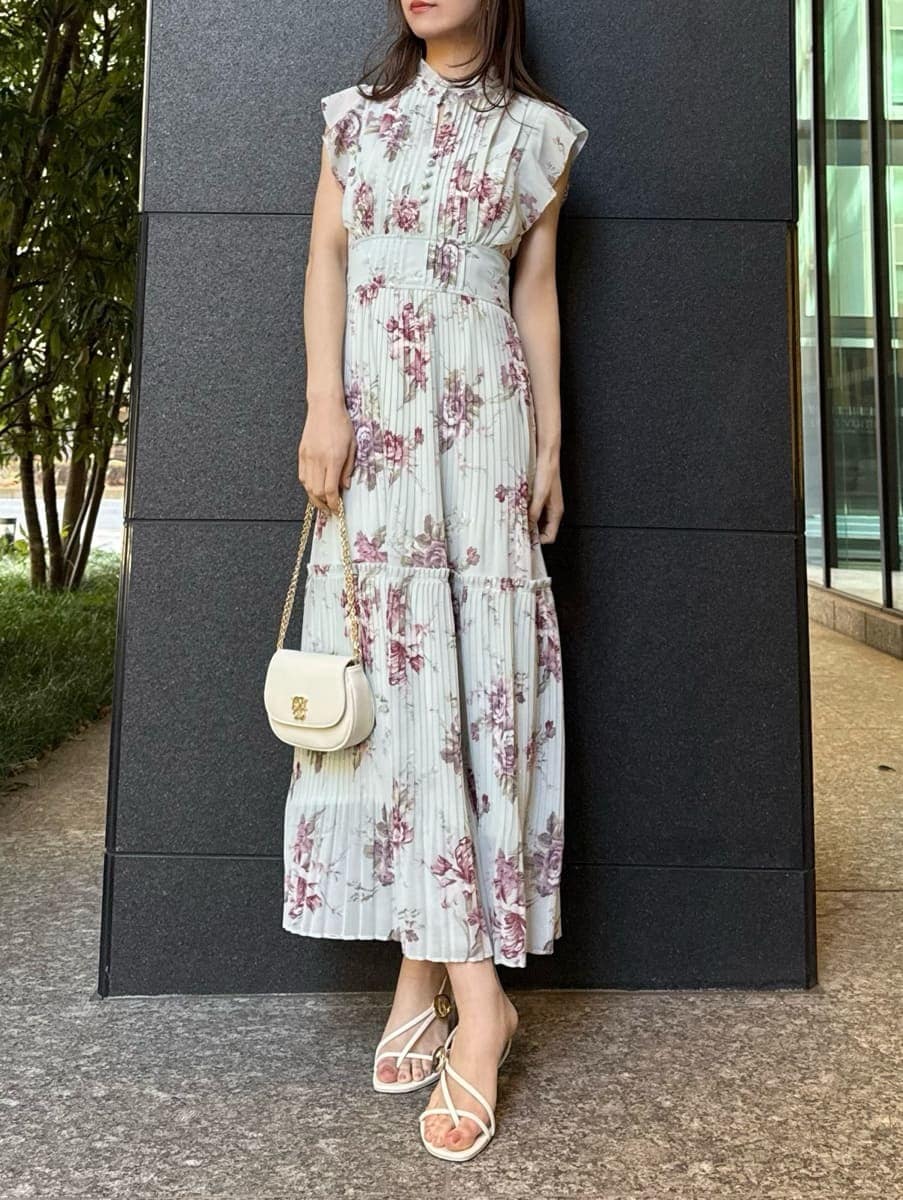 グリーン系のワンピース、ホワイト系のショルダーバッグ、ゴールド系のイヤリングを着用したレディースの春コーディネートの5枚目の写真