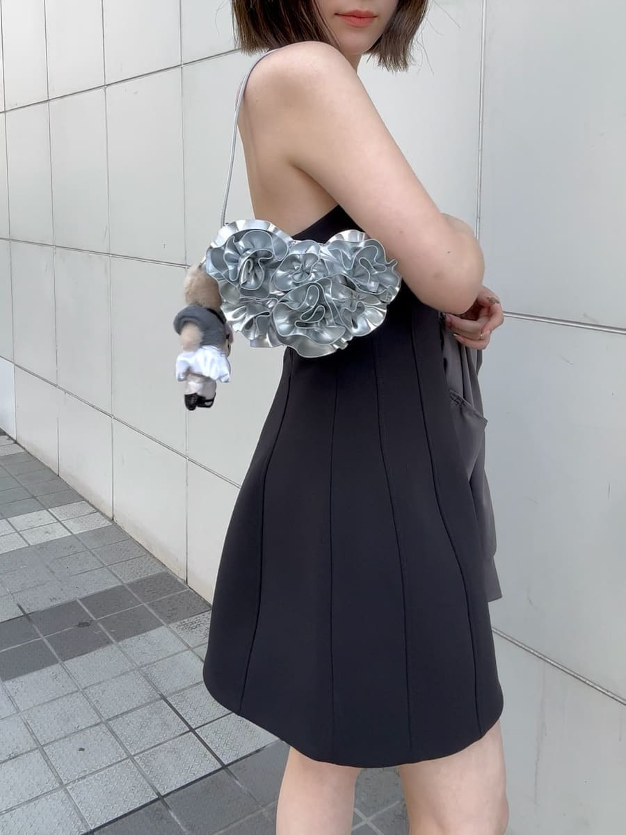 ブラック系のワンピース、シルバー系のハンドバッグ、ブラック系のローファーを着用したレディースの冬コーディネートの7枚目の写真