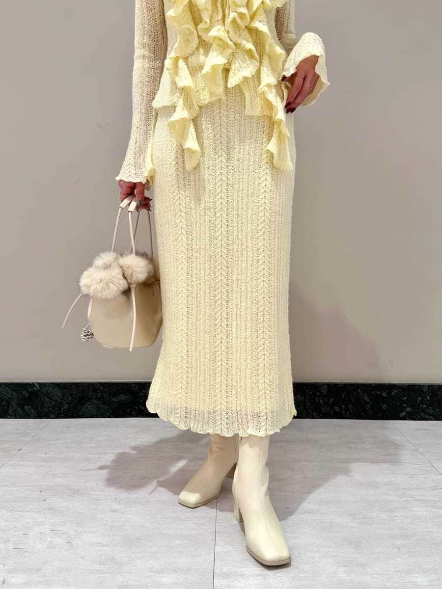 イエロー系のスカート、イエロー系のニット/セーター、ホワイト系のハンドバッグを着用したレディースの秋コーディネートの5枚目の写真