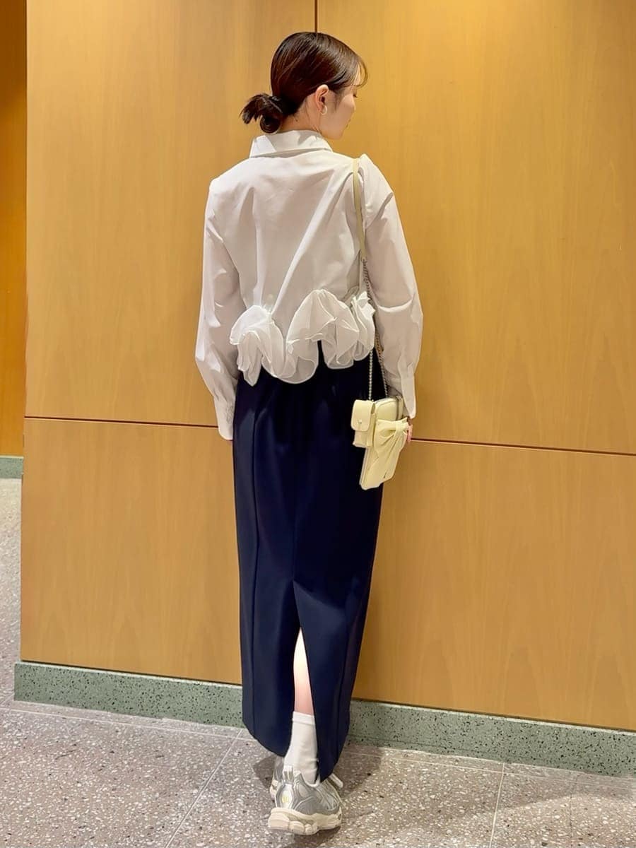 ブルー系のスカート、ホワイト系のシャツ/ブラウス、イエロー系のショルダーバッグを着用したレディースの冬コーディネートの4枚目の写真