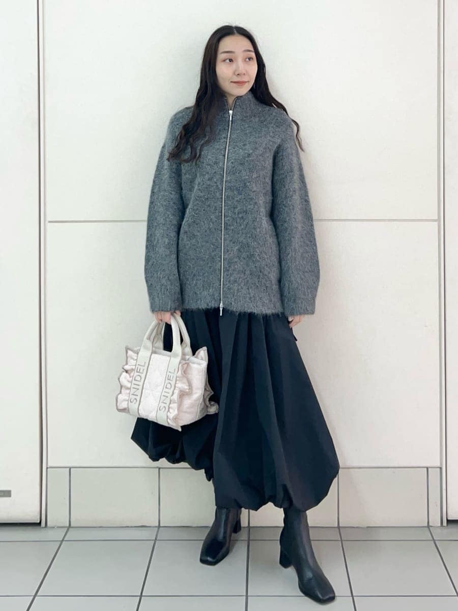グレー系のブルゾン、ブラック系のスカート、ピンク系のハンドバッグを着用したレディースの秋コーディネートの2枚目の写真