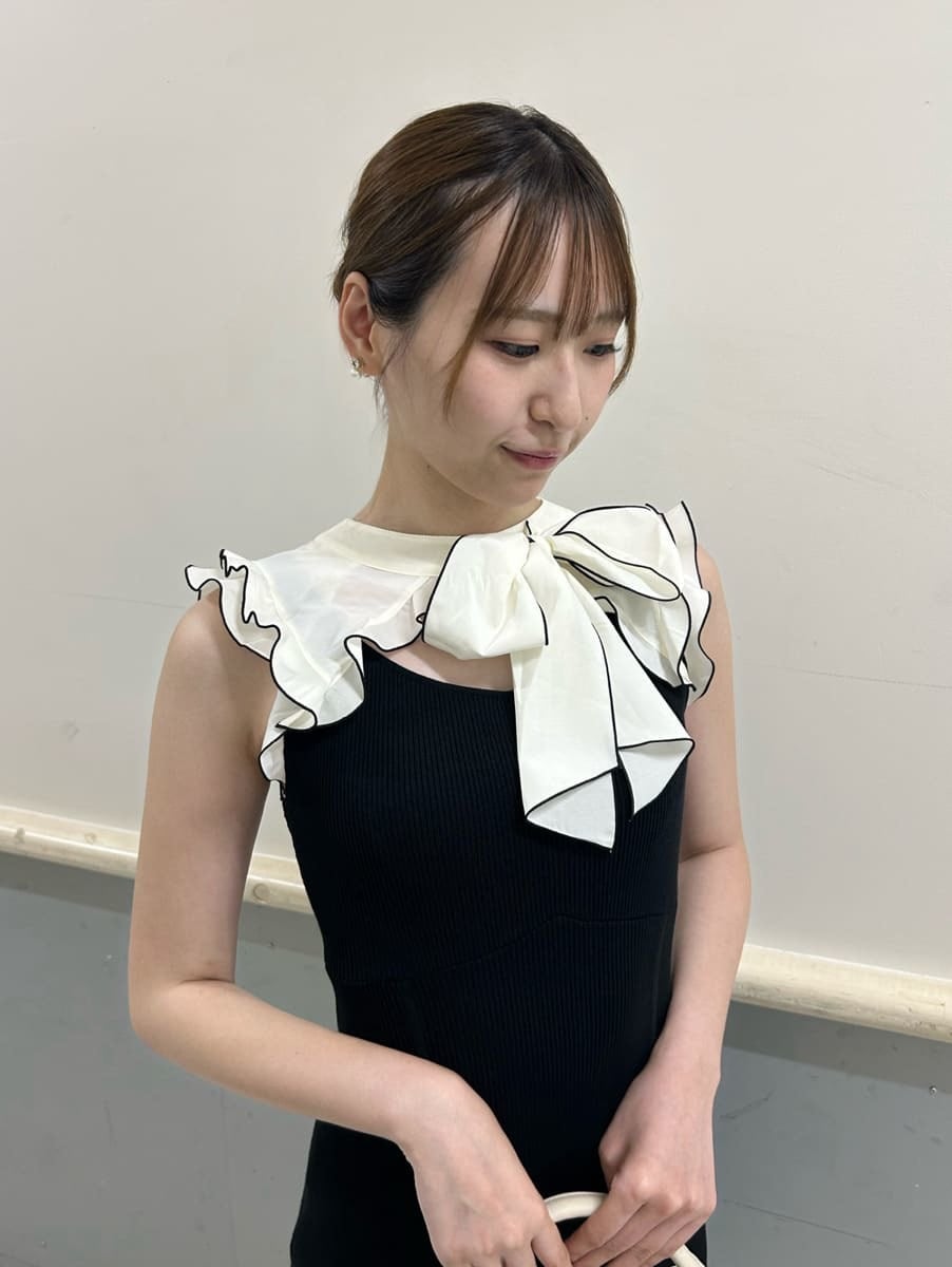 ホワイト系のハンドバッグ、ブラック系のワンピース、ブラック系のサンダルを着用したレディースの夏コーディネートの3枚目の写真