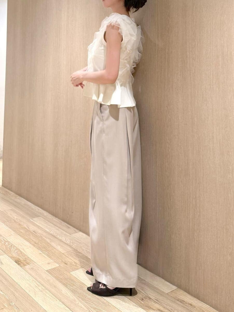 ベージュ系のその他パンツ、ホワイト系のニット/セーター、ブラウン系のサンダルを着用したレディースの夏コーディネートの2枚目の写真