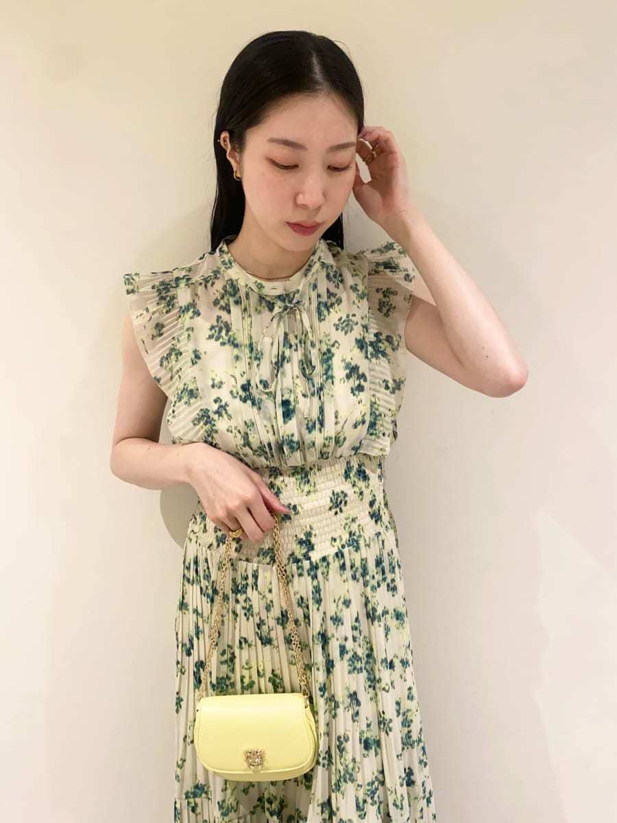 グリーン系のワンピース、ホワイト系のテーラードジャケット、イエロー系のショルダーバッグを着用したレディースの冬コーディネートの7枚目の写真