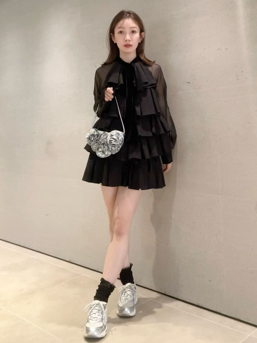 ブラック系のドレス、シルバー系のスニーカーを着用したレディースの冬コーディネートの7枚目の写真