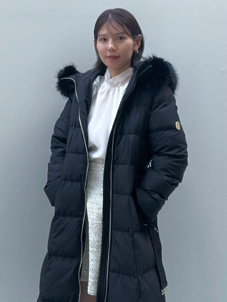 ホワイト系のスカート、ブラック系のブーツ、ブラック系のダウンジャケット/コートを着用したレディースの冬コーディネートの2枚目の写真