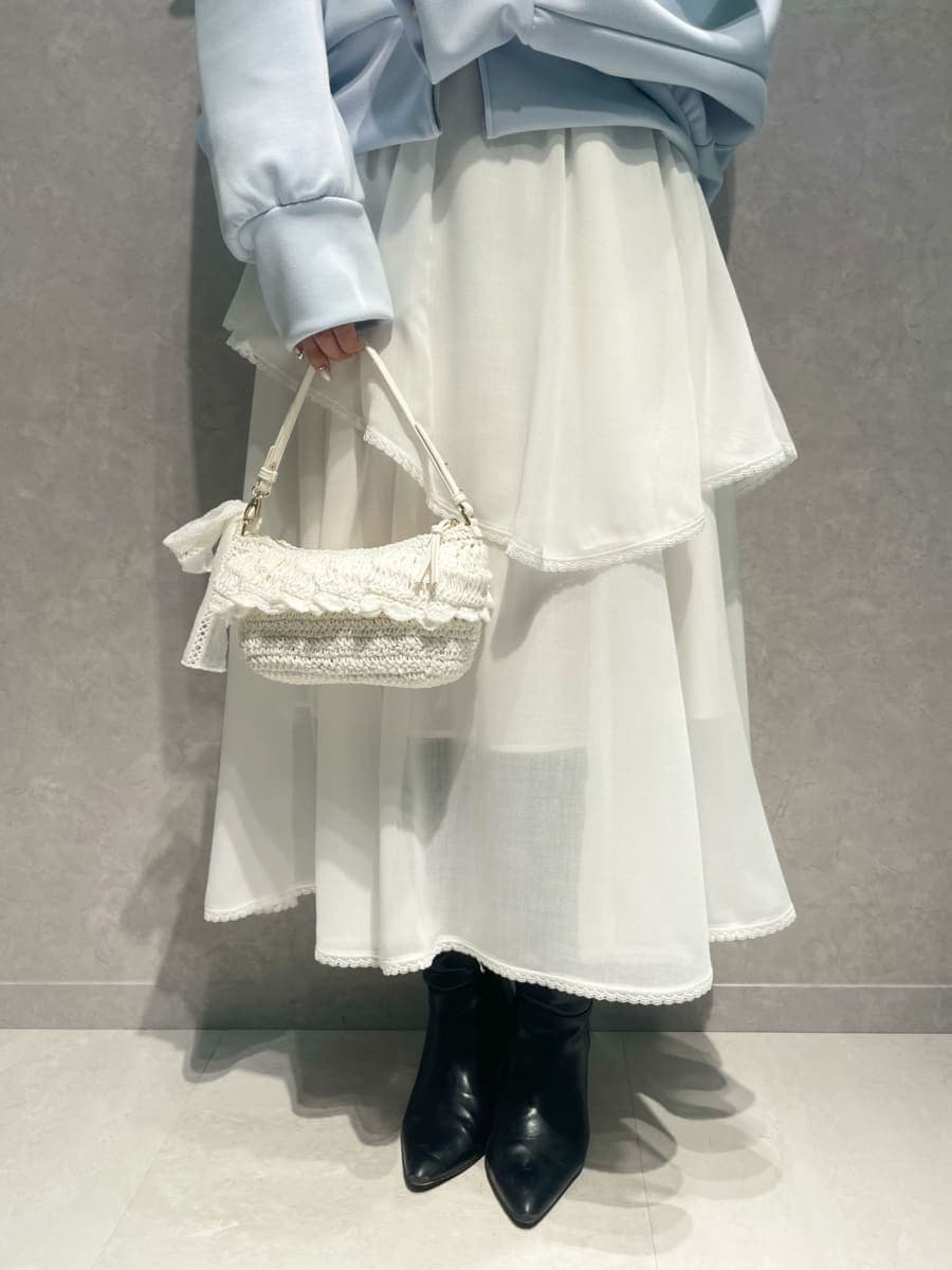 ブラック系のブーツ、ホワイト系のスカート、ブルー系のパーカーを着用したレディースの冬コーディネートの5枚目の写真