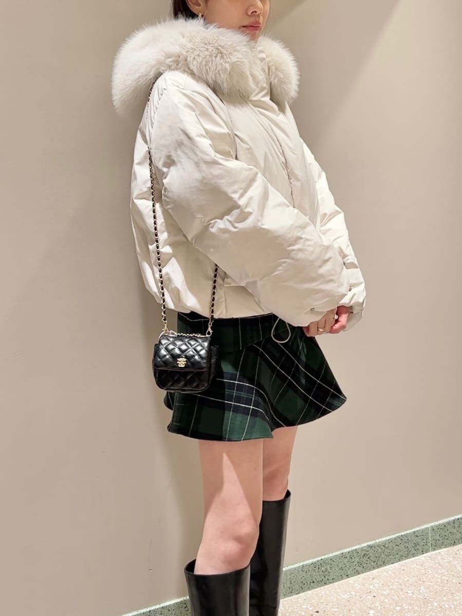 ブラック系のブーツ、ブラック系のショルダーバッグ、ホワイト系のダウンジャケット/コートを着用したレディースの冬コーディネートの2枚目の写真