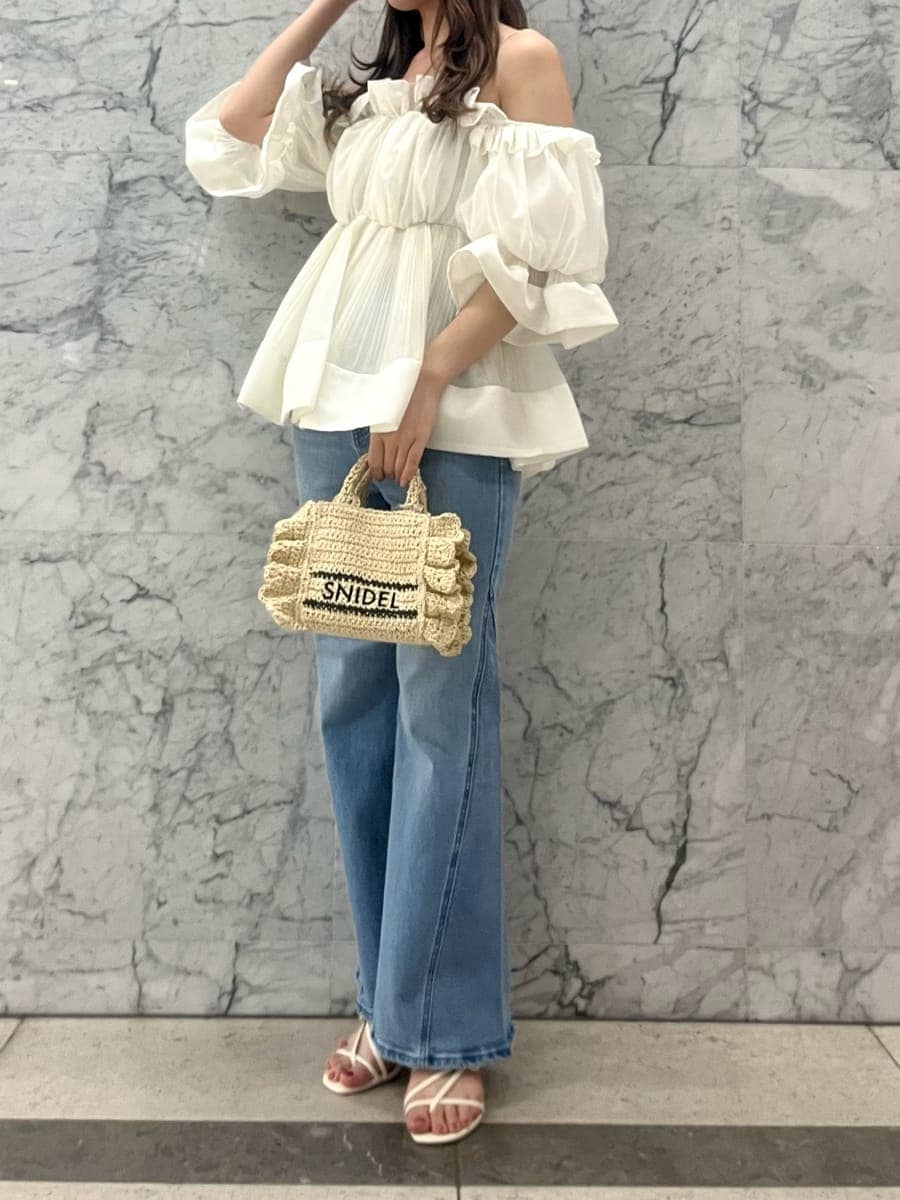 ブルー系のデニムパンツ、ホワイト系のその他トップス、ベージュ系のショルダーバッグを着用したレディースの春コーディネートの2枚目の写真