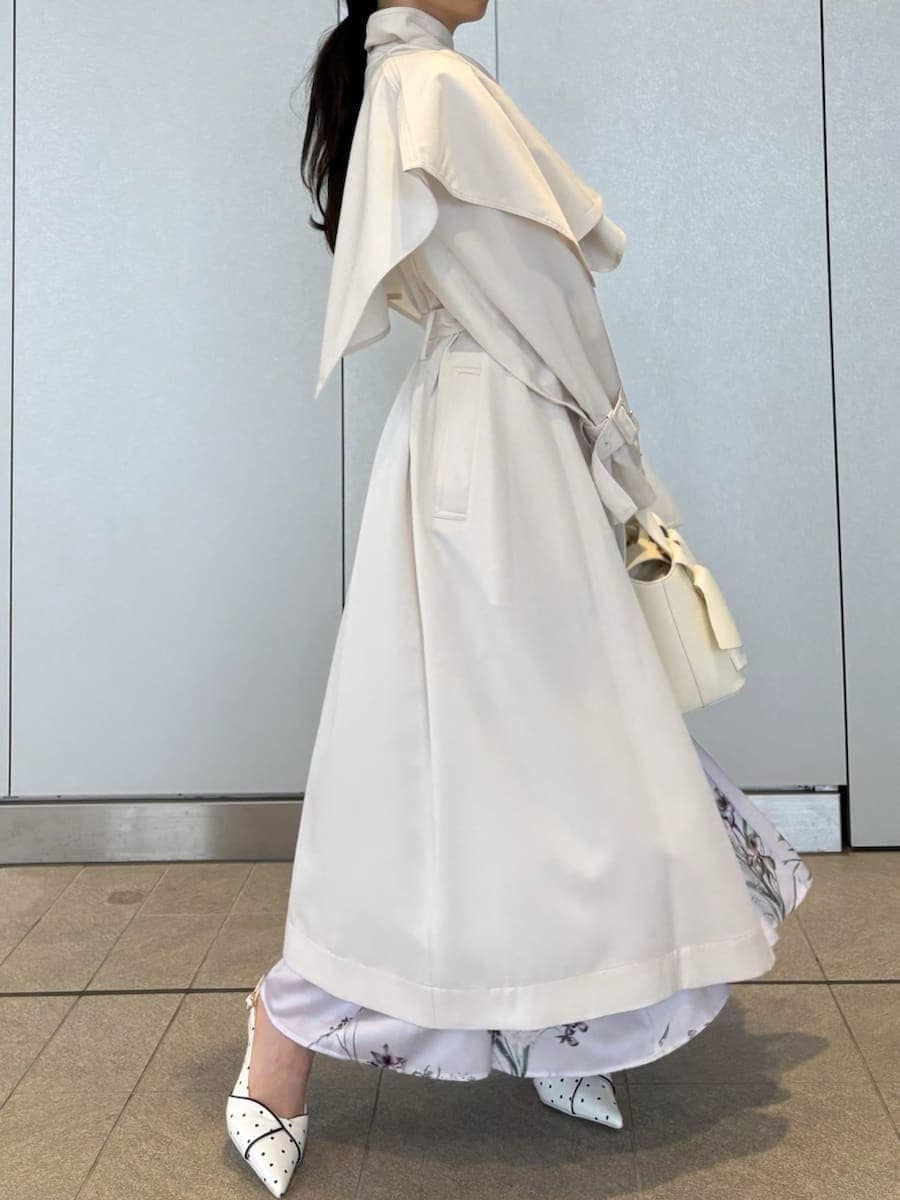 ホワイト系のトレンチコート、パープル系のワンピース、その他のパンプスを着用したレディースの冬コーディネートの8枚目の写真