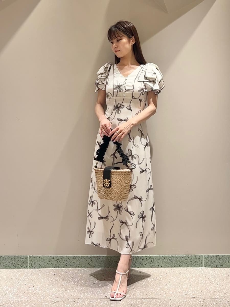 ホワイト系のワンピース、ブラック系のかごバッグ、ホワイト系のサンダルを着用したレディースの夏コーディネートの3枚目の写真