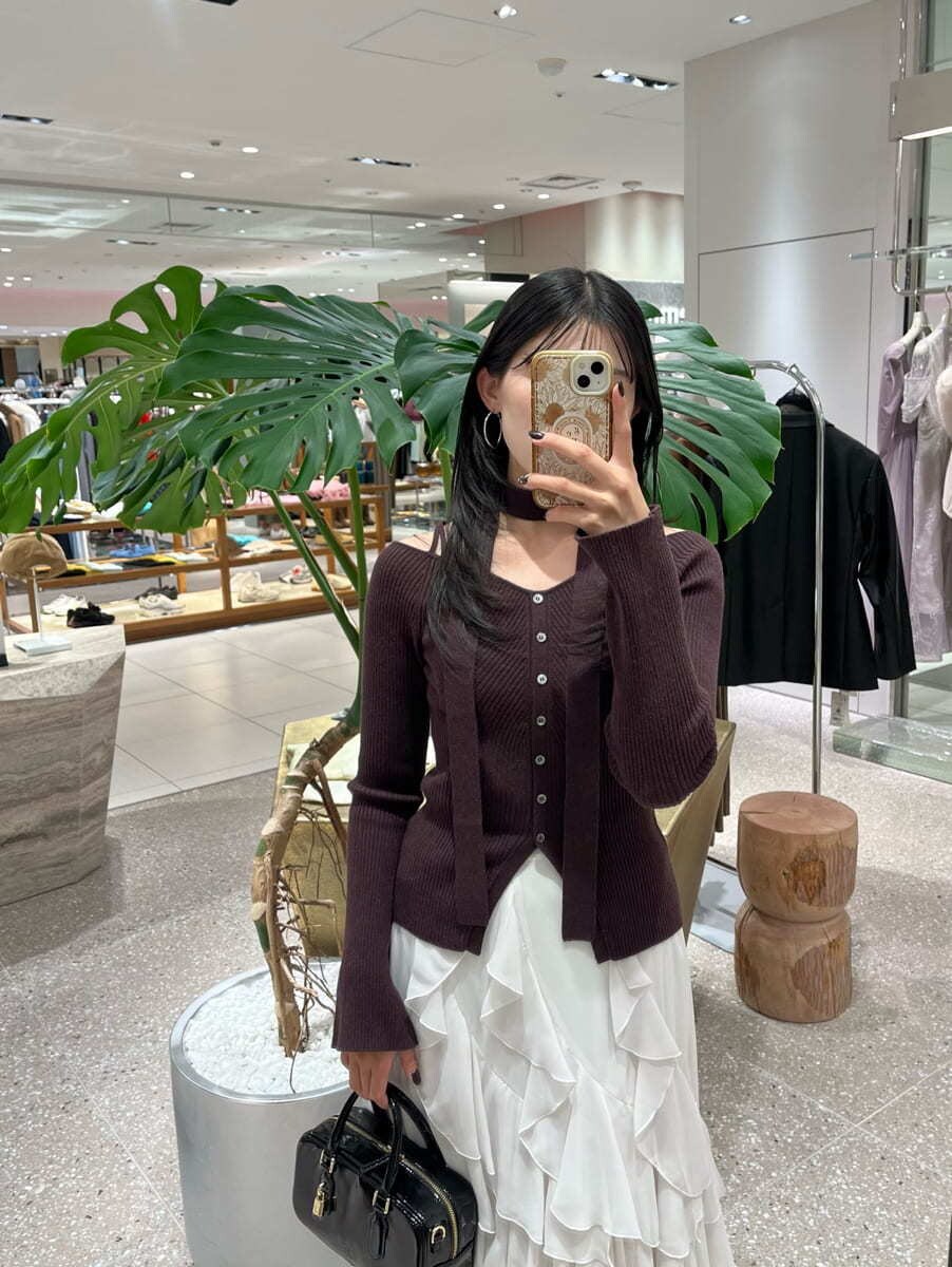 ブラウン系のニット/セーター、ホワイト系のスカート、ブラック系のボストンバッグを着用したレディースの秋コーディネートの7枚目の写真