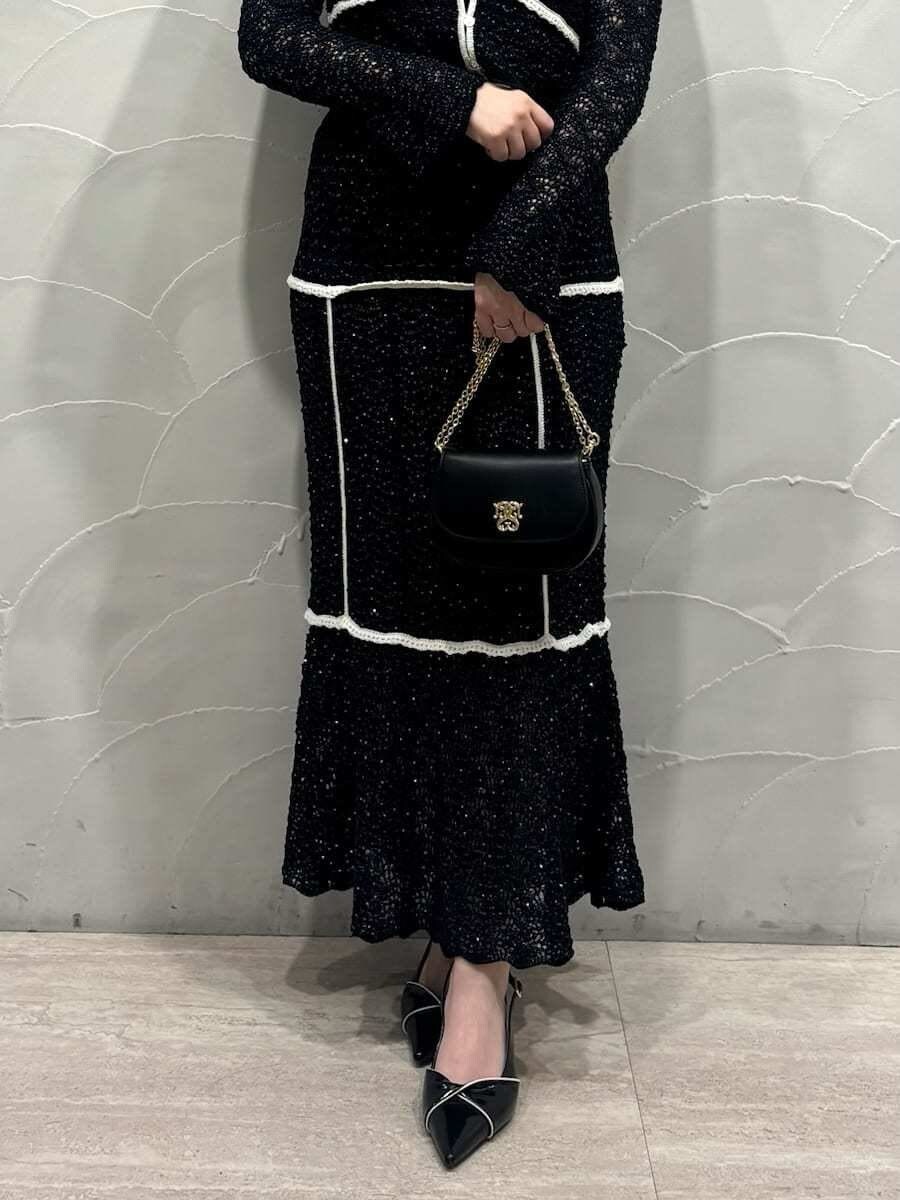 ブルー系のスカート、ブルー系のニット/セーター、ブラック系のパンプスを着用したレディースの冬コーディネートの5枚目の写真