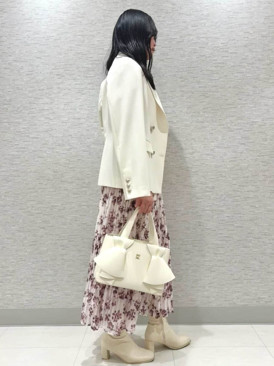 ピンク系のワンピース、ホワイト系のテーラードジャケット、ホワイト系のハンドバッグを着用したレディースの冬コーディネートの2枚目の写真