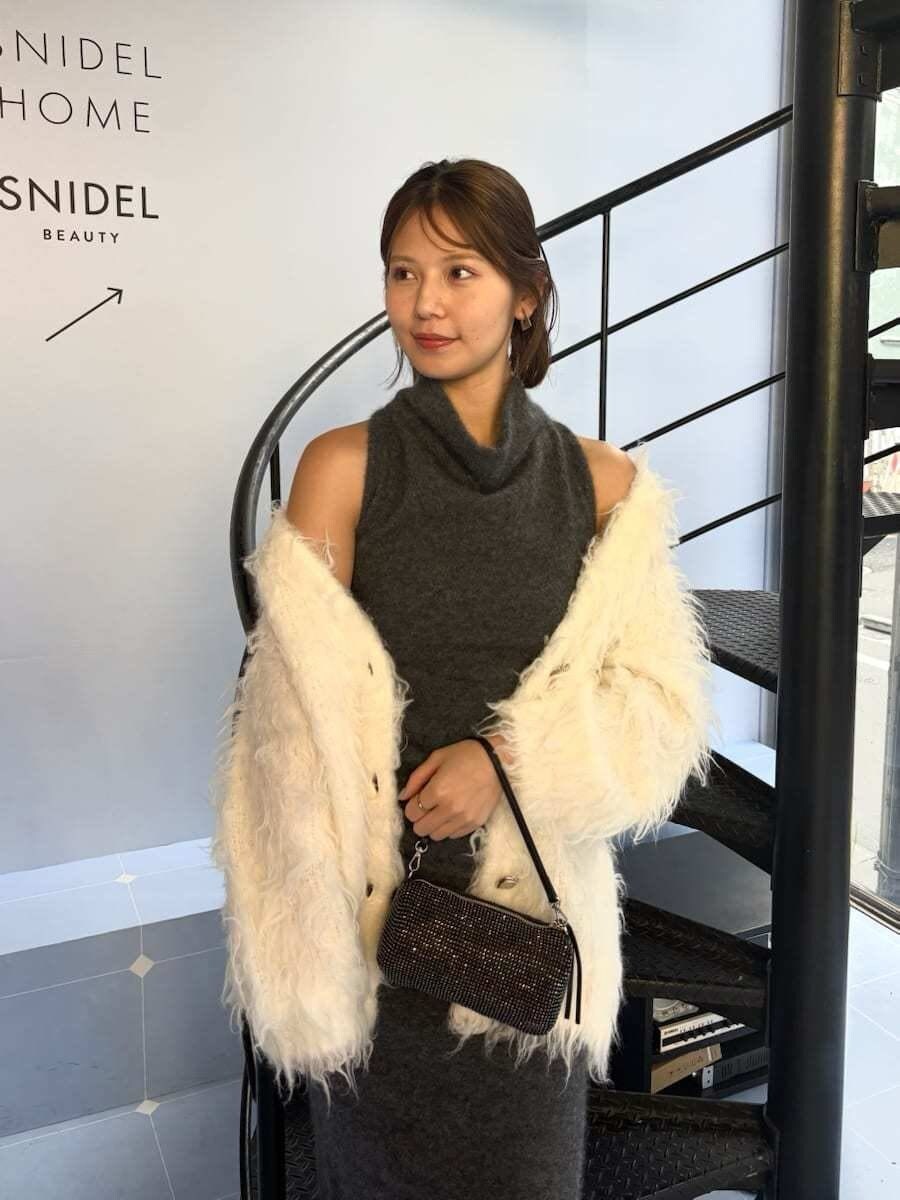 グレー系のワンピース、ホワイト系のカーディガン/ボレロを着用したレディースの冬コーディネートの5枚目の写真