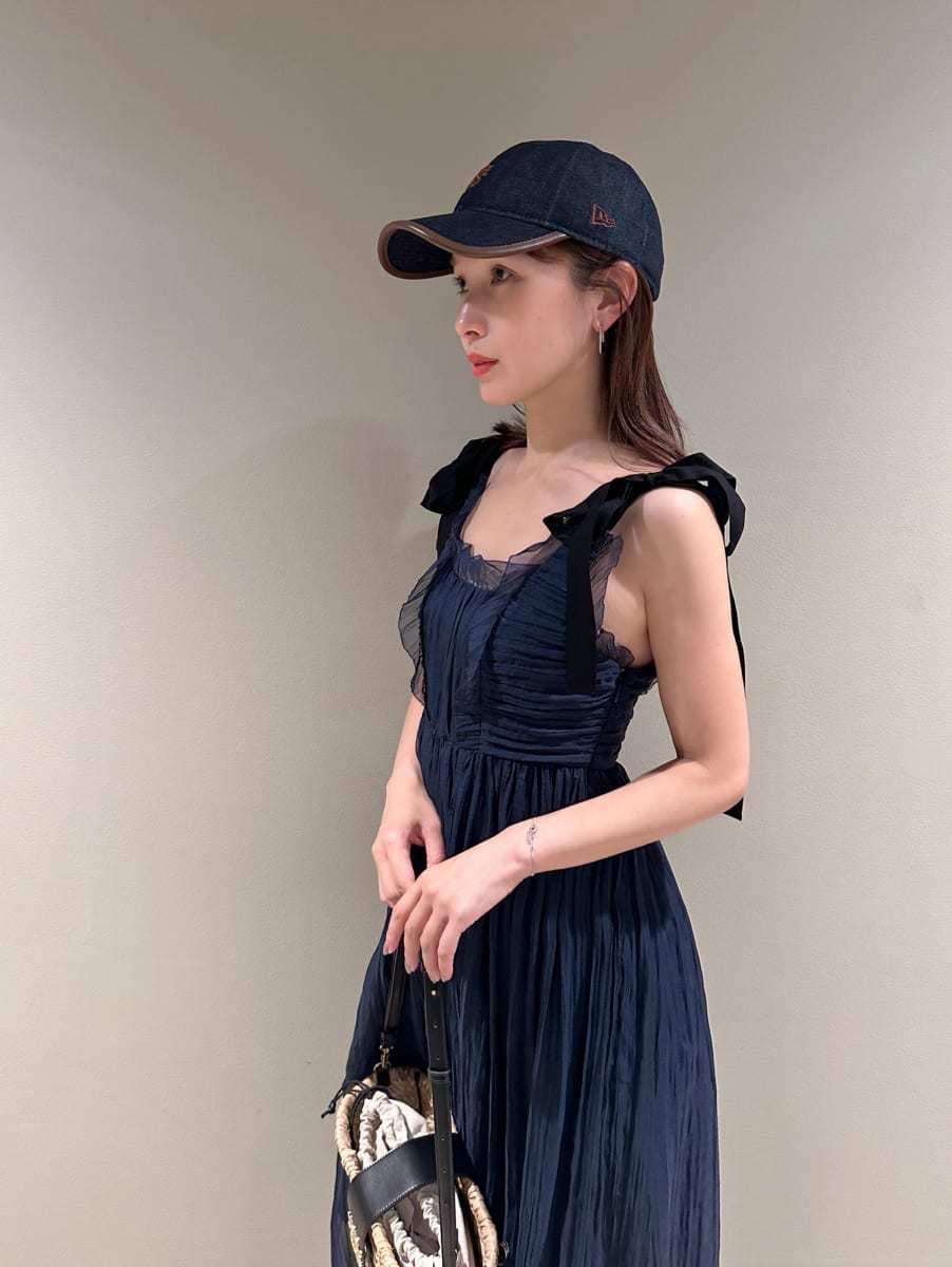 ブルー系のワンピース、その他のパンプス、ブラック系のかごバッグを着用したレディースの夏コーディネートの2枚目の写真