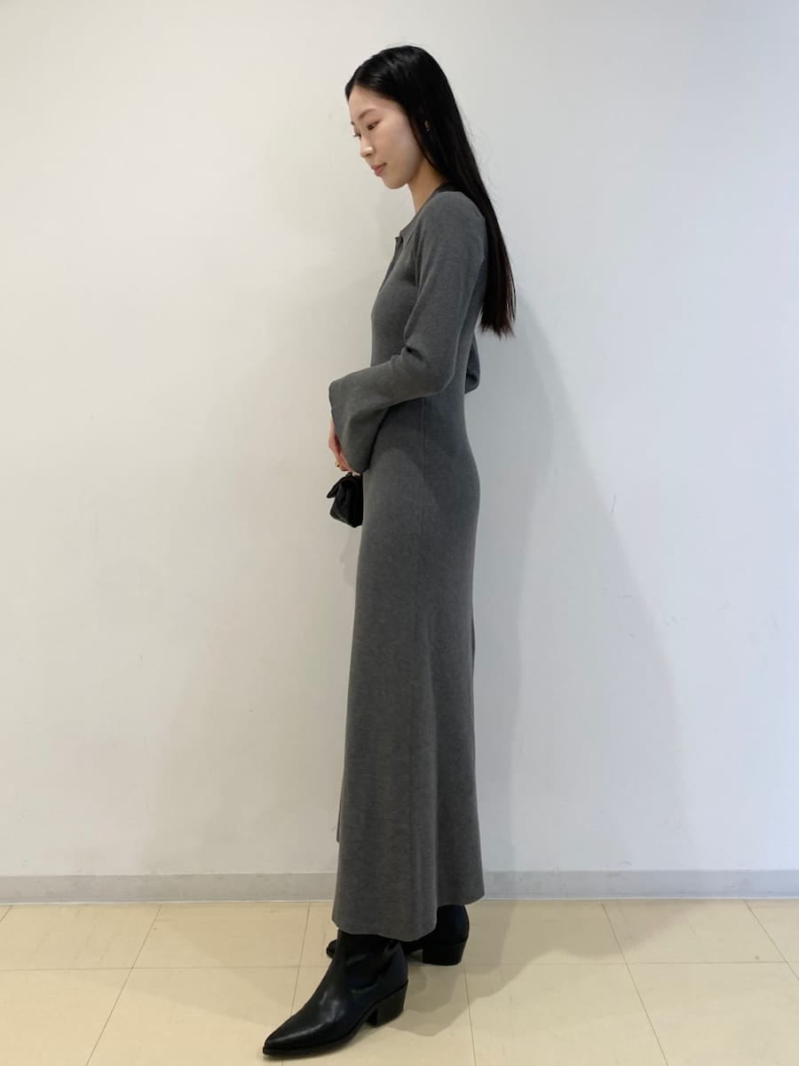 ブラック系のパンプス、ブラック系のショルダーバッグ、グレー系のワンピースを着用したレディースの冬コーディネートの2枚目の写真