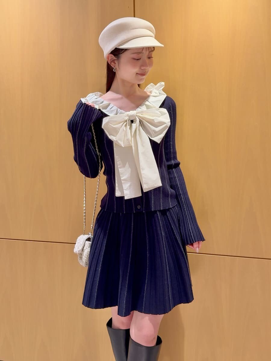 ブラック系のブーツ、ホワイト系のショルダーバッグ、ベージュ系のチェスターコートを着用したレディースの冬コーディネートの5枚目の写真