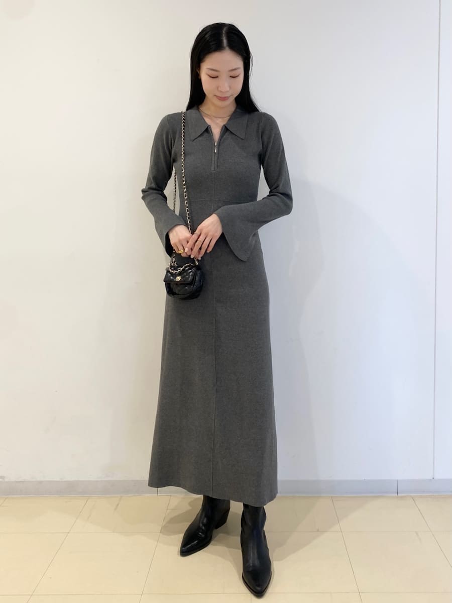 ブラック系のパンプス、ブラック系のショルダーバッグ、グレー系のワンピースを着用したレディースの冬コーディネートの4枚目の写真