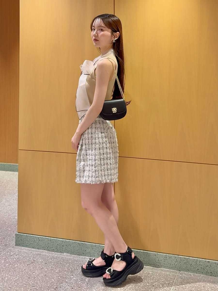 ブラック系のショルダーバッグ、ホワイト系のその他パンツ、ベージュ系のニット/セーターを着用したレディースの夏コーディネートの3枚目の写真