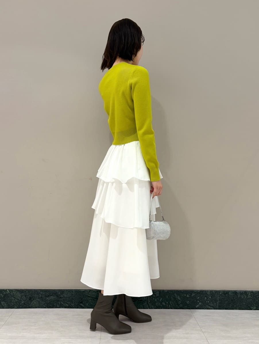 イエロー系のワンピース、ゴールド系のイヤリングを着用したレディースの冬コーディネートの2枚目の写真