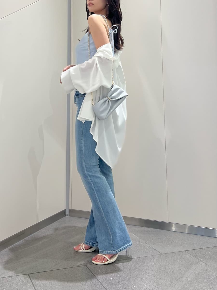 ブルー系のデニムパンツ、ホワイト系のサンダルを着用したレディースの春コーディネートの2枚目の写真