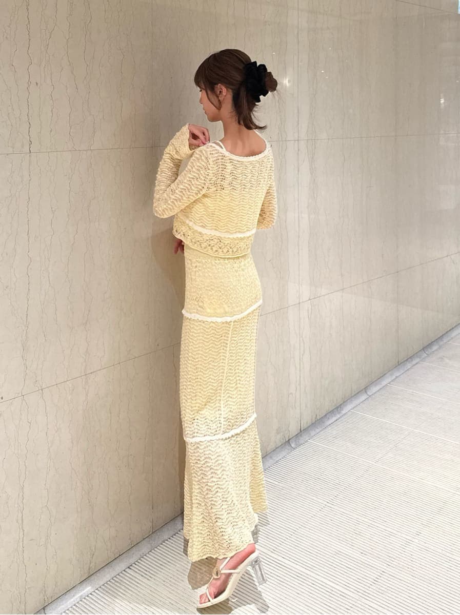 ホワイト系のキャミソール、イエロー系のスカートを着用したレディースの冬コーディネートの2枚目の写真